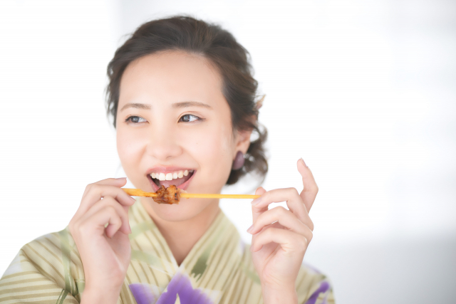 焼き鳥を食べる女性
